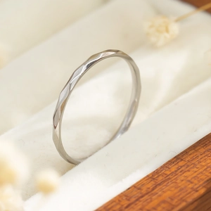 Close-up van een zilveren titanium stalen ring met geometrische textuur in een doosje