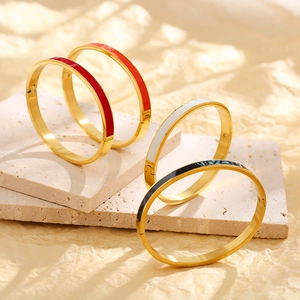 Detail of hinged 18k gold-plated stainless steel bangles with colorful enamel inlay