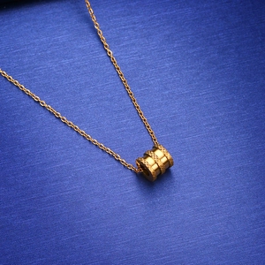 Elegante gouden titanium stalen ketting met getextureerde cilindrische hanger aan een O-ketting