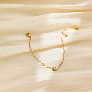 Detail of delicate 18k gold plated stainless steel chain with a round zircon stone