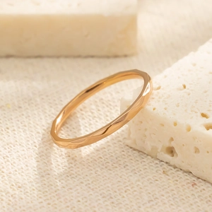 Detail van een minimalistische titanium stalen ring met gehamerde roségouden finish