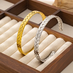 Macro di bracciali a C in oro e argento con texture a spiga di grano su base in velluto
