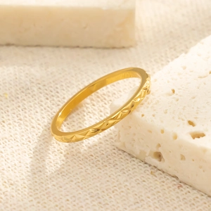 Detailweergave van de gouden titaniumstalen ring met minimalistisch ruitvormig patroon