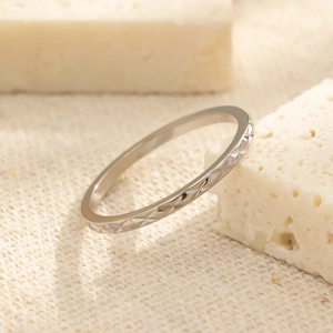 Detail macro-opname van een minimalistische zilveren ring op een natuurlijke koraalsteen