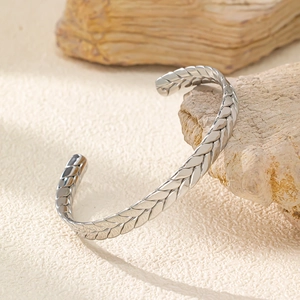Vista dettagliata del bracciale rigido a treccia in acciaio inossidabile su pietra