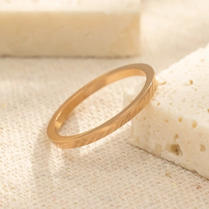 Macro-opname van een roségouden titanium ring met diagonale patronen op stenen basis