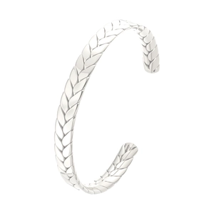 Dettaglio macro del motivo a spiga di grano su bracciale rigido in acciaio lucido
