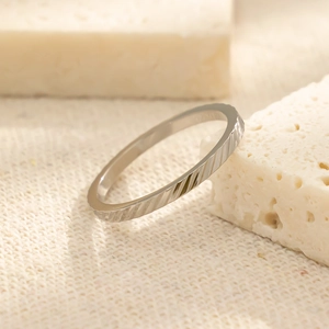 Detailopname van een zilveren titanium stalen ring met minimalistische diagonale strepen
