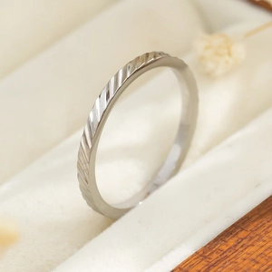 Macro-detail van een zilverkleurige titaniumstalen ring met golvend patroon op fluweel