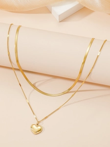 Detail einer doppelten Goldkette mit flacher Schlangenkette und Love You Herzanhänger