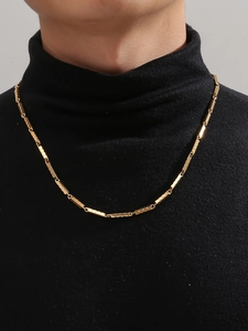 Close-up of golden bamboo chain link necklace for men worn on a black sweater