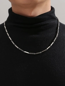 Close-up of minimalist silver titanium steel chain necklace on black turtleneck sweater