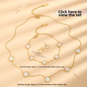 Makroaufnahme von Goldschmuckset mit weißen Kleeblatt-Inlays aus Perlmutt auf Kette