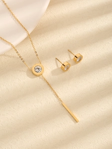 Detail des goldenen Schmucksets mit römischem Ziffernanhänger und Quastenohrringen