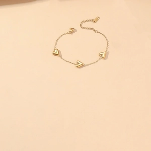Detail of gold heart charms on a delicate chain with lobster clasp and extension
