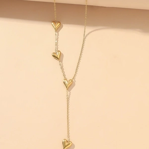 Elegant gold-tone long necklace with four polished heart charms on a minimalist thin chain