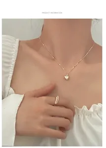 Detailed close-up of textured heart pendant necklace and elegant pearl ring on a model