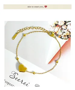 Detail of gold titanium steel bracelet featuring heart pendant and beaded chain links