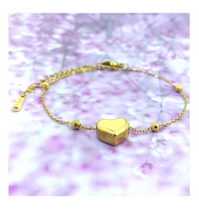Macro shot of gold heart pendant and steel link chain with lobster clasp and extender