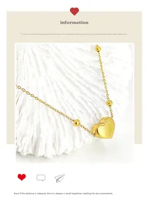 Close-up of golden heart pendant necklace with round beads on white seashell texture