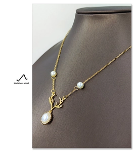 Dettaglio ravvicinato della collana a corna di cervo in acciaio inox con perle e zirconi