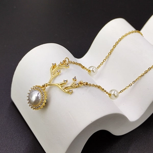 Elegante collana dorata a forma di corna con ciondolo di perle e accenti di zirconi