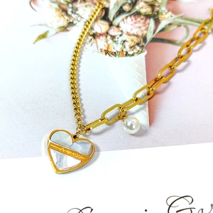 Collier en acier titane doré à chaîne asymétrique avec pendentif cœur et perle