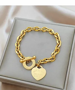Dettaglio di un bracciale dorato in acciaio inossidabile con cuore in un cofanetto
