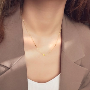 Elegante gouden titanium hartketting gedragen door een model in een minimalistische stijl