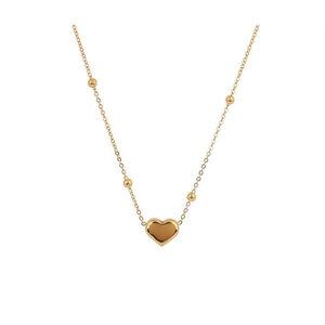 Collana minimalista con ciondolo a cuore in oro e catena a sfere su sfondo bianco