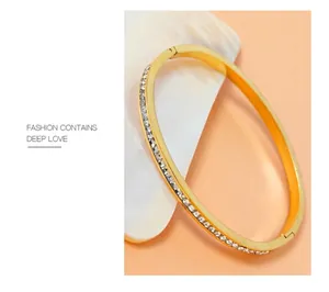 Detail of gold titanium steel bangle featuring a micro-set sparkling diamond-encrusted band