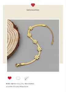 Détail d'un bracelet chaîne serpent plaqué or 18k avec cinq petits charms de fleurs marguerites