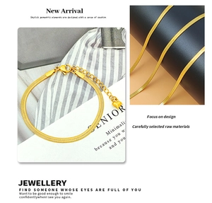Detailed macro view of 18K gold-plated flat snake chain bracelet with heart charm detail