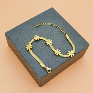 Bracelet marguerites en acier titane doré avec cinq breloques fleurs et fermoir ajustable