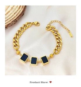 Detailansicht des Gold-Edelstahl-Kettenarmbands mit schwarzen Emaille-Quadrat-Anhängern