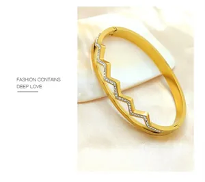 Detail of gold-plated zigzag bangle with sparkling crystals and hinge closure mechanism