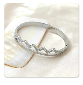 Close-up of silver stainless steel bangle with diamond-set zigzag cutout details