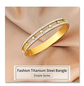 Detail of gold hollow titanium steel bracelet with stars and double row pavé crystals