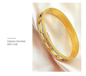 Macro detail of gold star bangle with hollow patterns and dual rows of inset crystals