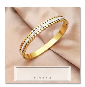 Close-up of gold titanium steel bangle with petal-shaped edges and white zircon inlay