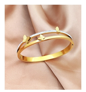 Close-up of golden titanium steel butterfly bangle with double-row sparkling crystals