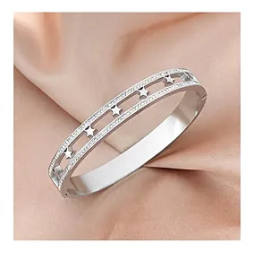 Detail of silver hollow star bracelet with sparkling crystals on satin background
