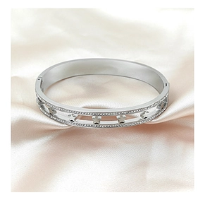 Macro detail of silver star cutout bracelet with pave-set rhinestones on satin