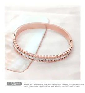 Detail of rose gold 316L titanium steel bangle with double row studs and zircon inlay