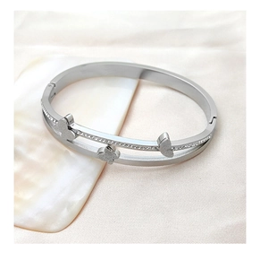 Close-up of silver butterfly bangle with double-row crystals on elegant silk background