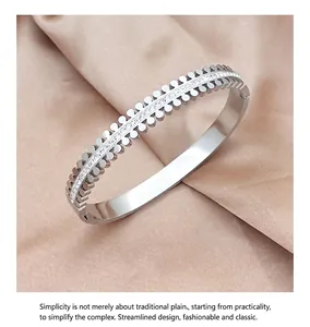 Detail of silver titanium bangle featuring twin rows of pavé crystals on silk fabric