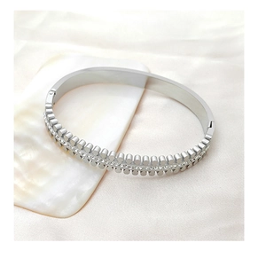 Macro shot of silver titanium bracelet with double row studs and pavé crystal setting