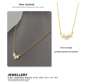 Macro detail of gold-plated petal pendant with zircon stones on a fine link chain
