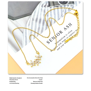 Detail of 18k gold plated titanium steel necklace featuring three zircon flower charms