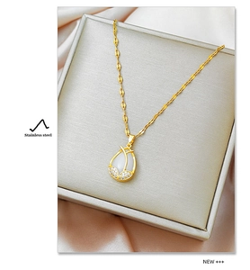 Detail of gold stainless steel necklace with water-drop cat-eye stone and small crystals